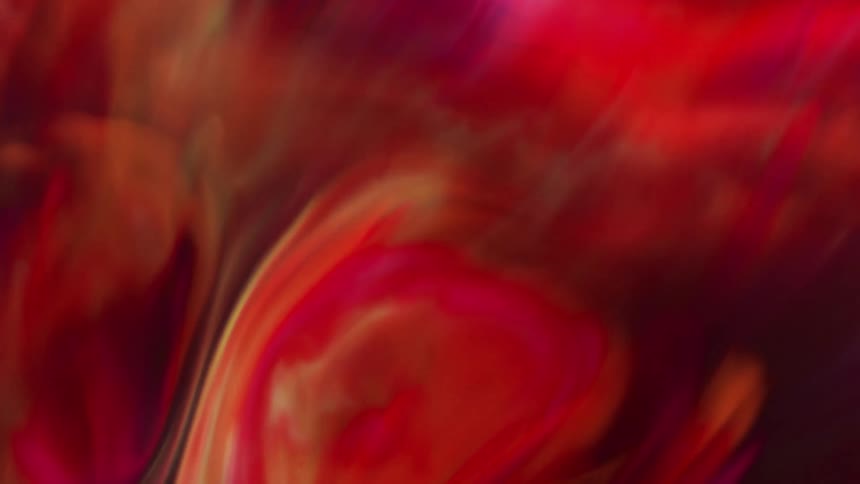 Extreme closeup of a dense and abstract red liquid in slow motion