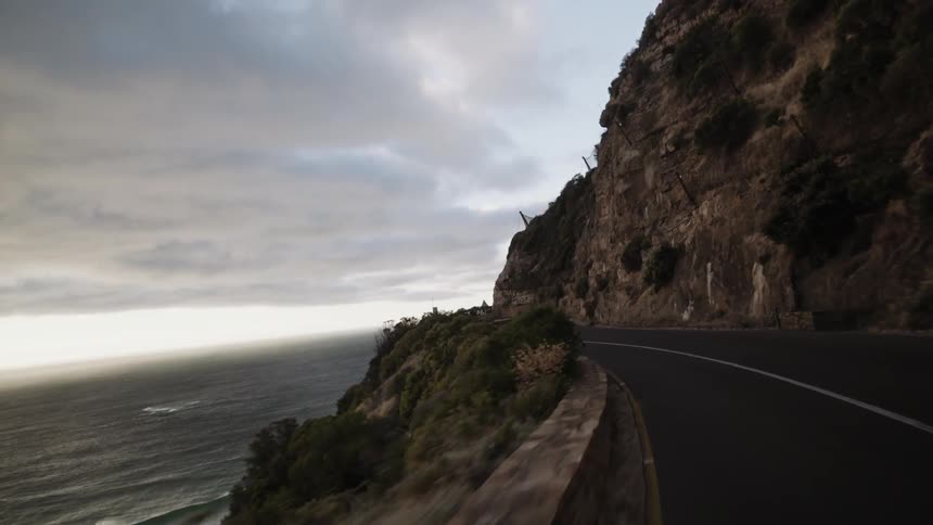A winding road between a mountain and an ocean