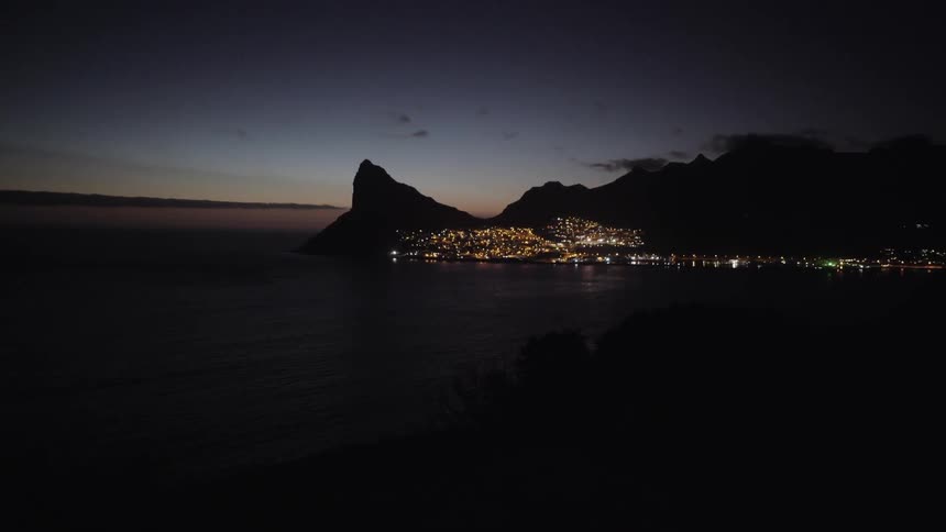 A brightly lit city near a body of water