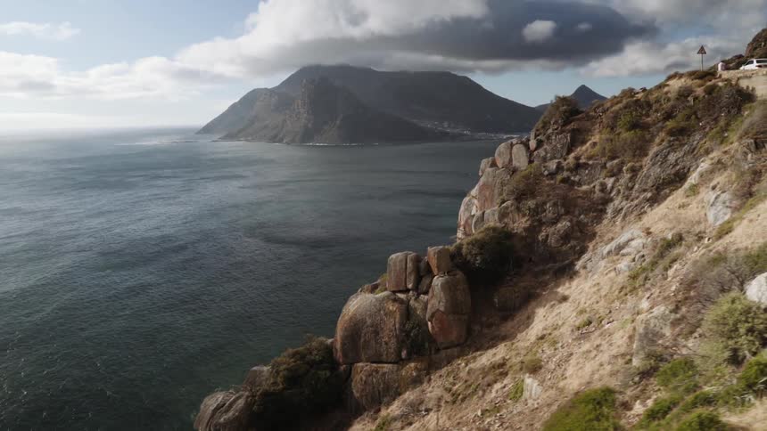 A rocky cliff leading toward a body of water