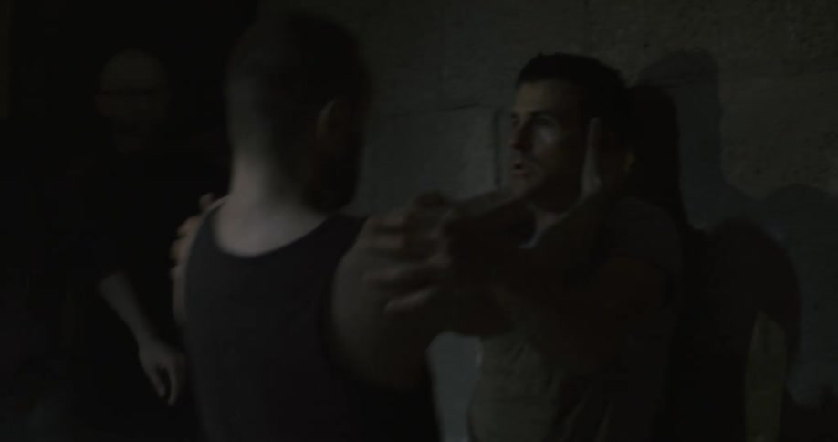 Two men are fighting each other in a dark ring