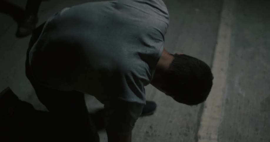 A man slowly pushes himself up from the ground