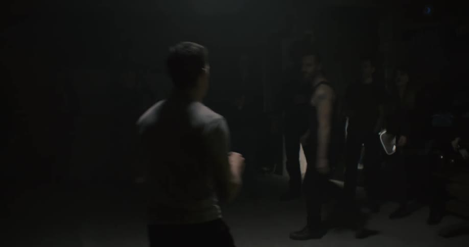 Two people fight in a dark room