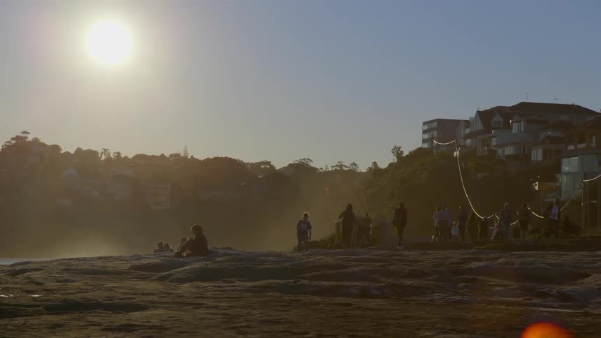 The sun shines down on a group of people on a beach
