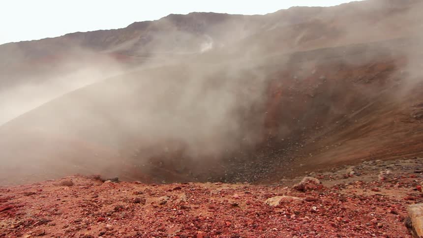Smoke floats over a crater in the ground
