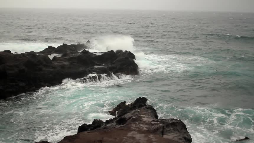 Waves hit the rocks in the rough shore below