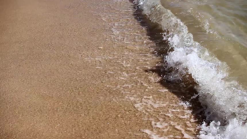 Ocean waves wash ashore a sandy beach