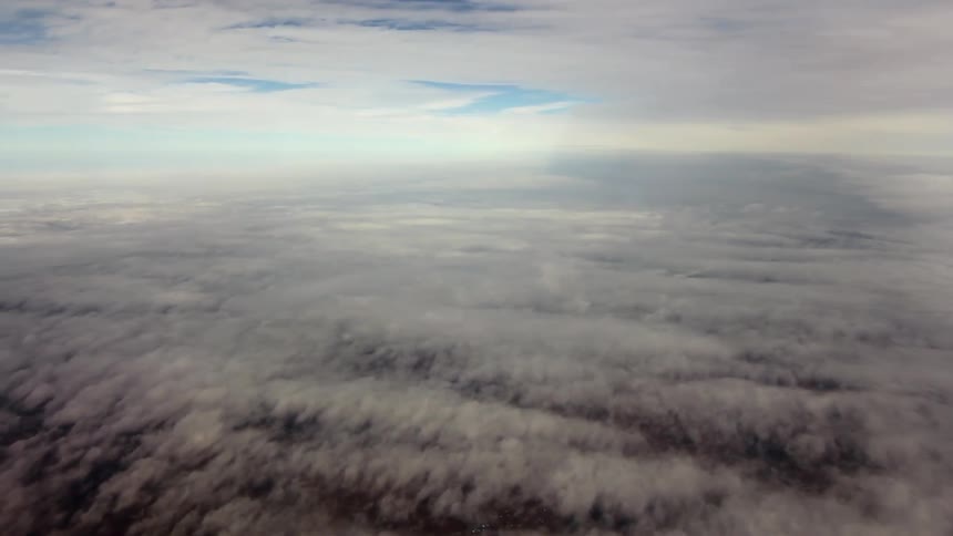 Heavy clouds sit below blocking the land