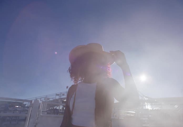 Smoke surrounds a woman standing in the rodeo arena