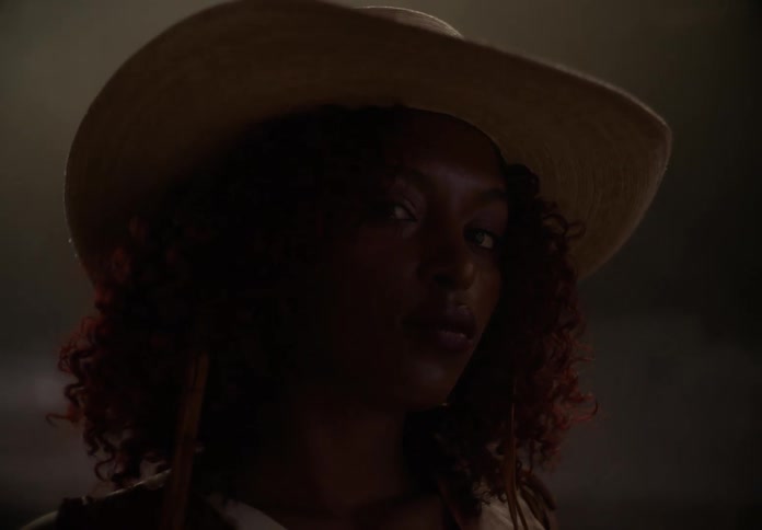 Closeup of a womans face wearing a cowboy hat
