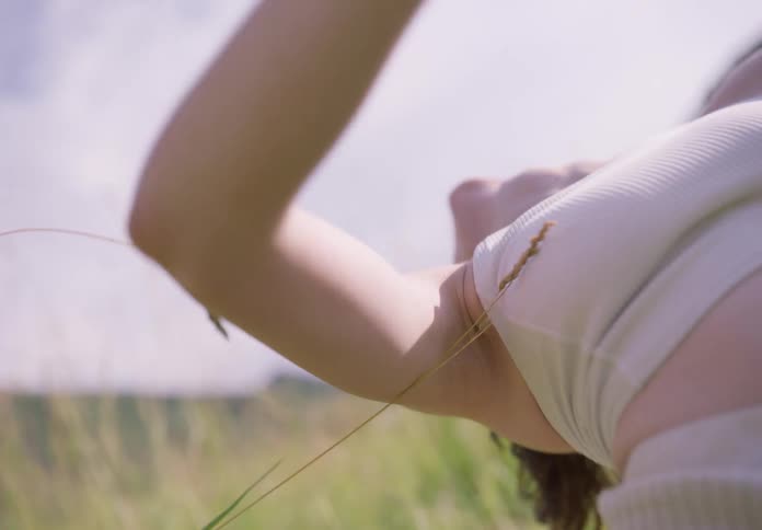 Young woman dancing in a crouched position in the midst of a field