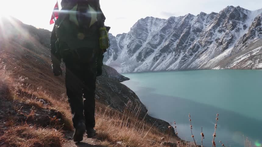 A man backpacking in the mountains next to a lake