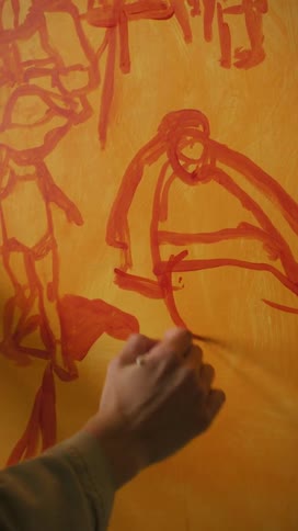 Woman standing in front of a canvas painting a picture