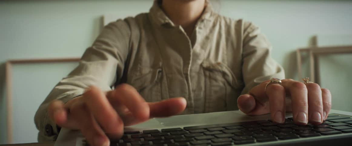 Hands of a woman typing on a laptop