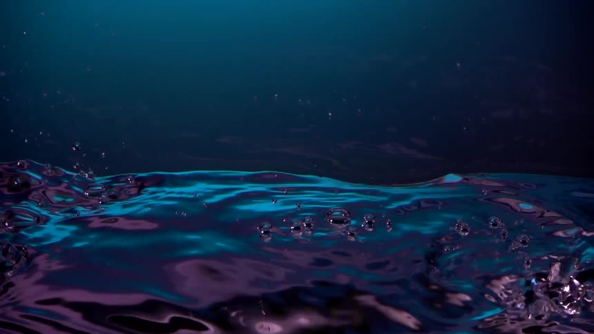 Upside down footage of air bubbles on clear neon water