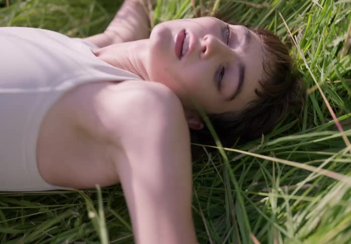 A woman rolls around in the grass