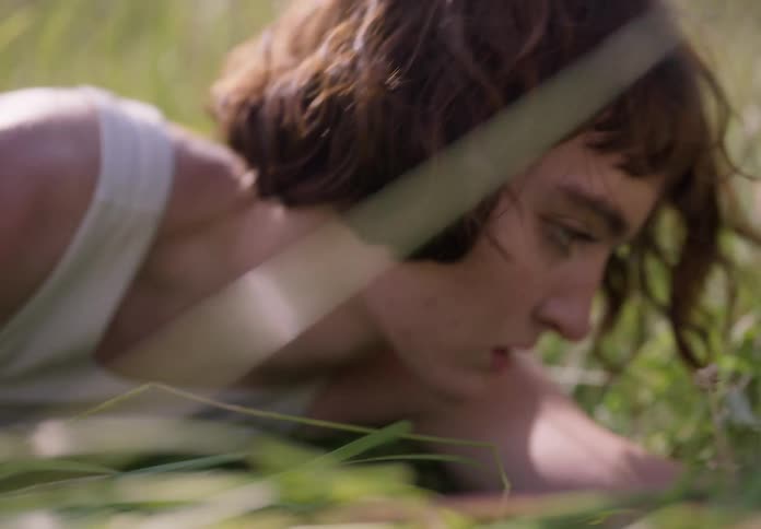 Lady lays on grass outdoor on a sunny day