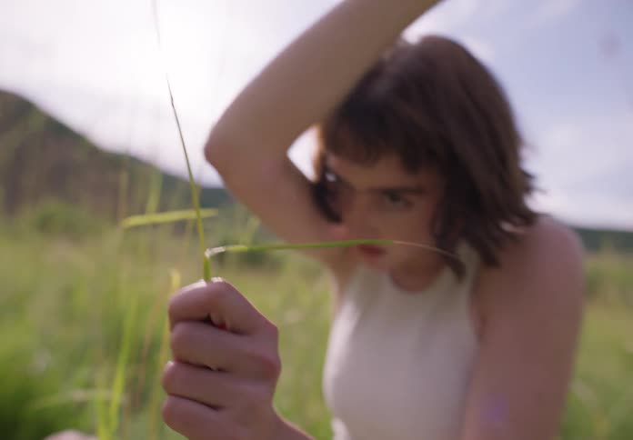 A woman playing with tall grass