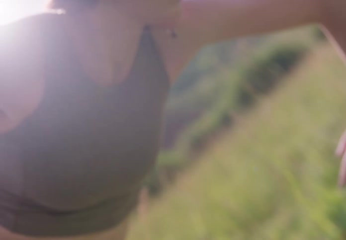 Woman wearing tanktop dances outdoors