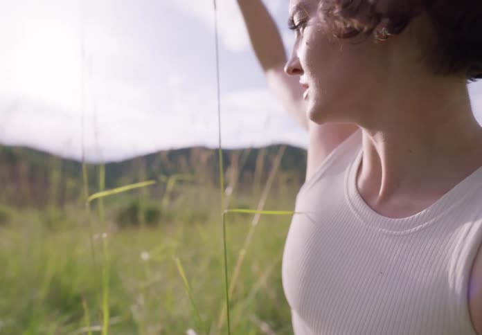 Woman dancing scenically while sitting amidst the bushes