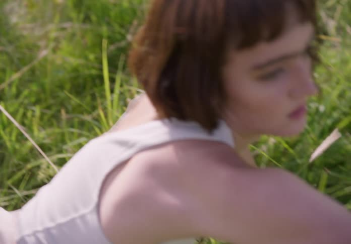 A young girl dances in a field during the day
