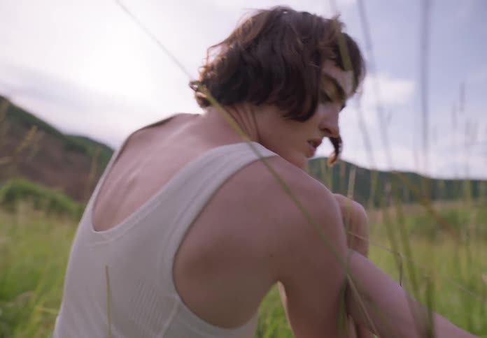 Woman dancing with her back to the camera in the midst of nature in a scenic performance
