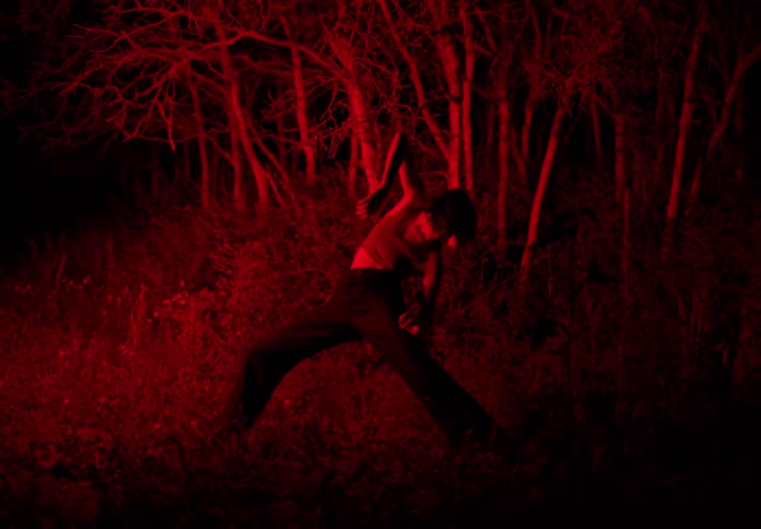 Woman dances moves outdoors under red light