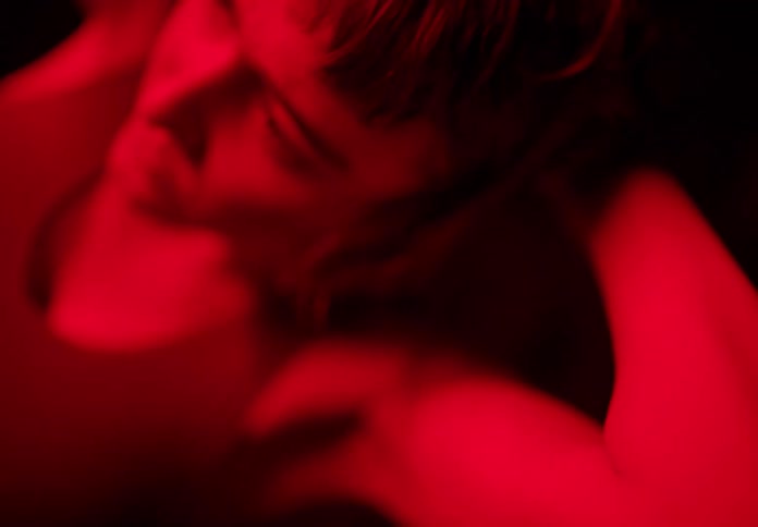 Young woman dancing and stretching under red lights