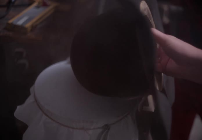 A person making a hat in a factory