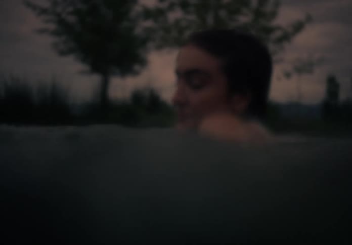 Portrait of a young woman in the pool on a late afternoon