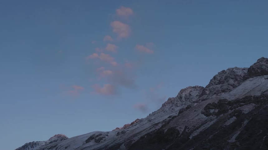 View of mountains with snowcapped peaks against a blue sky