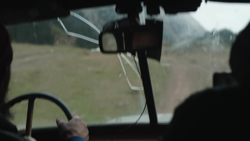 A man driving along a dirt road in the flat landscape with mountains