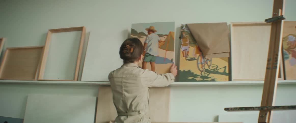Lady placed an artwork on the shelf inside the art studio at midday