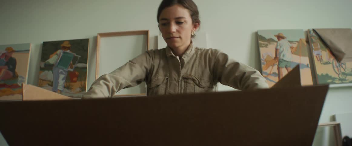 Woman placing paintings inside a box