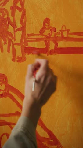 Closeup of a womans hands painting a canvas