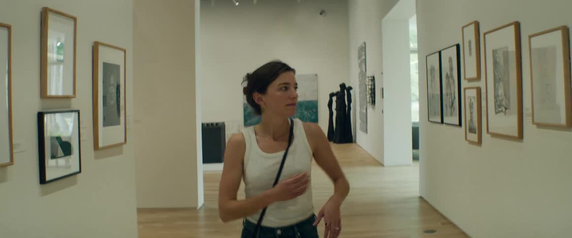 Portrait of a woman in a museum looking at an art exhibition