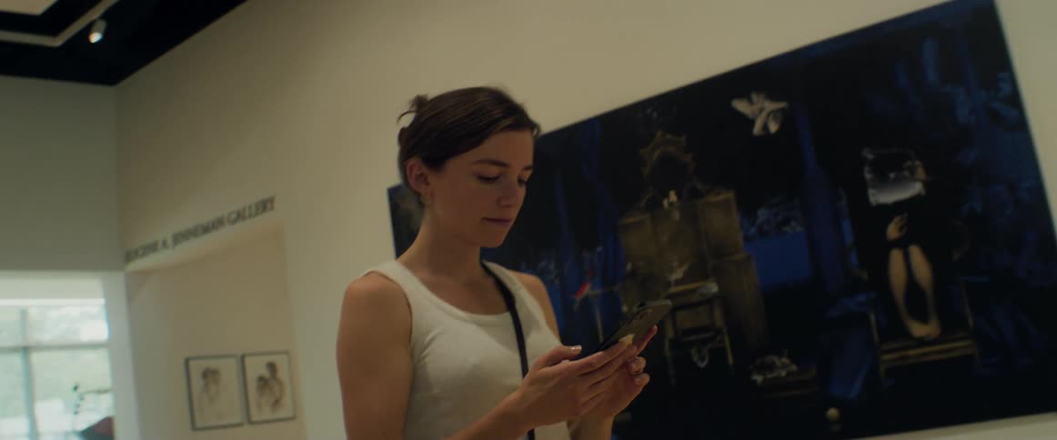 A woman takes a photo of the painting in the museum