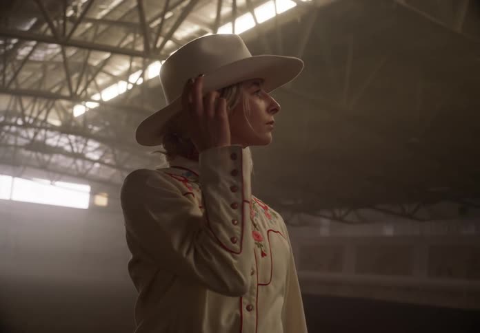 Woman wearing cowboy clothes models inside a large hangar