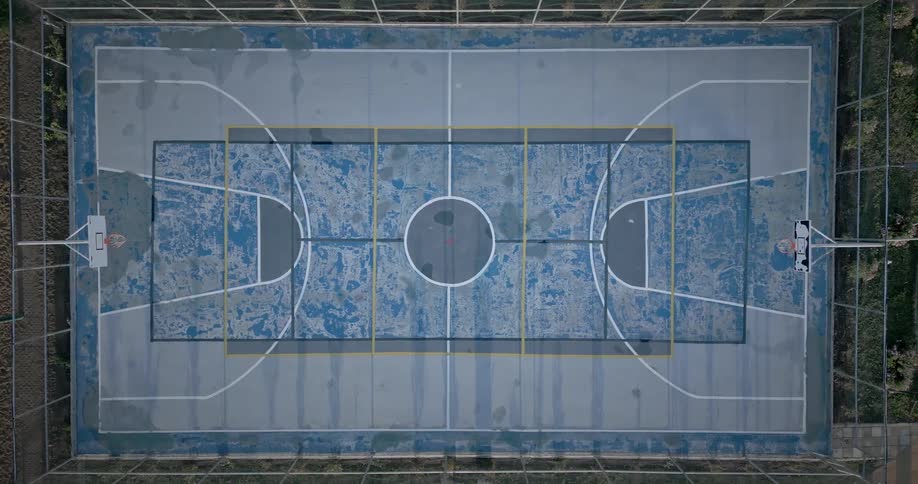 Aerial view of a cement basketball court in an outdoor setting