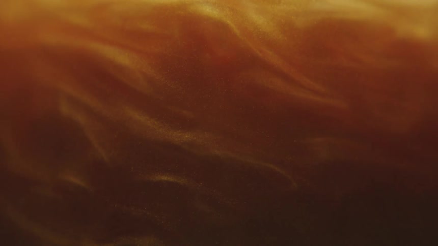 Dense and golden shimmering fluid in slow motion
