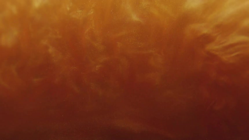 Thick amber shimmering liquid swirling