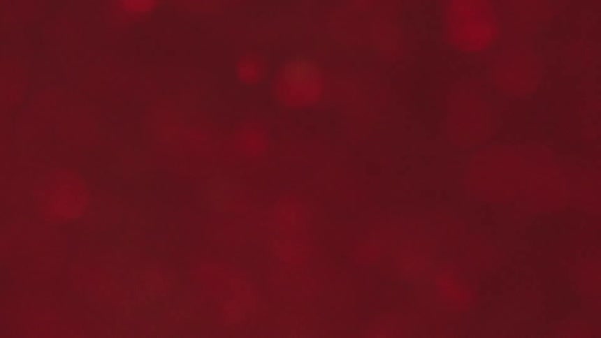 Extreme closeup of a dense red and shiny abstract liquid in slow motion