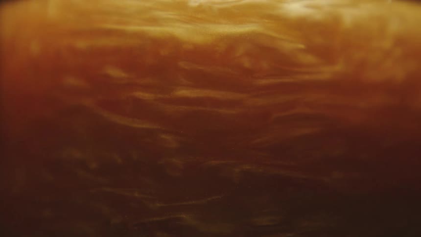 Golden and abstract fluid in a swirling motion in slow motion