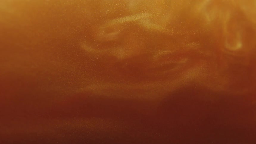 Thick amber shimmering liquid swirling