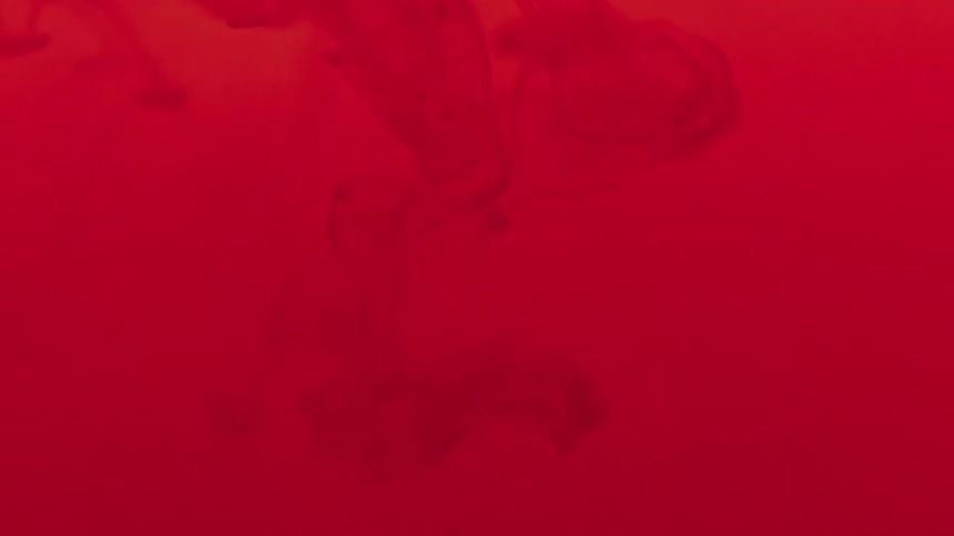 Abstract red fluid blending in water in slow motion
