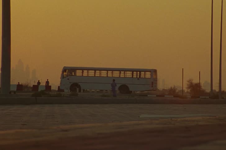 A person walking through the streets of a rural town during sunset