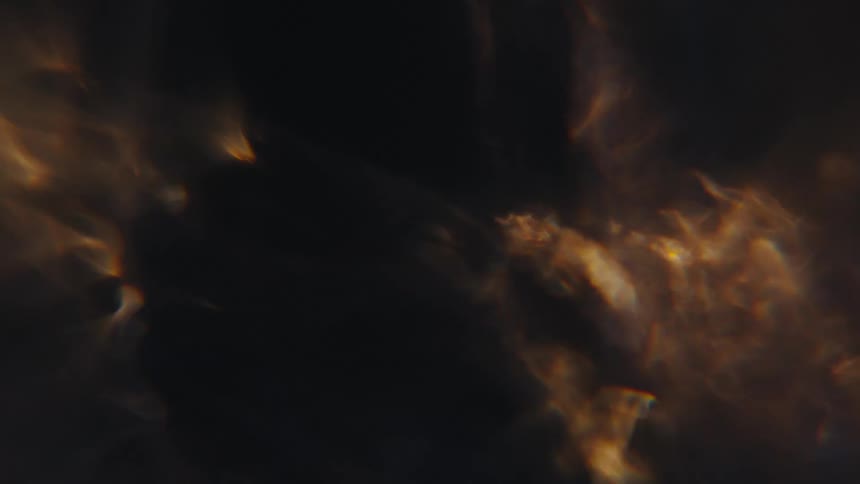 Light shines through dark churning water