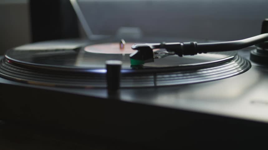 A vinyl record album spins on a turntable as it plays