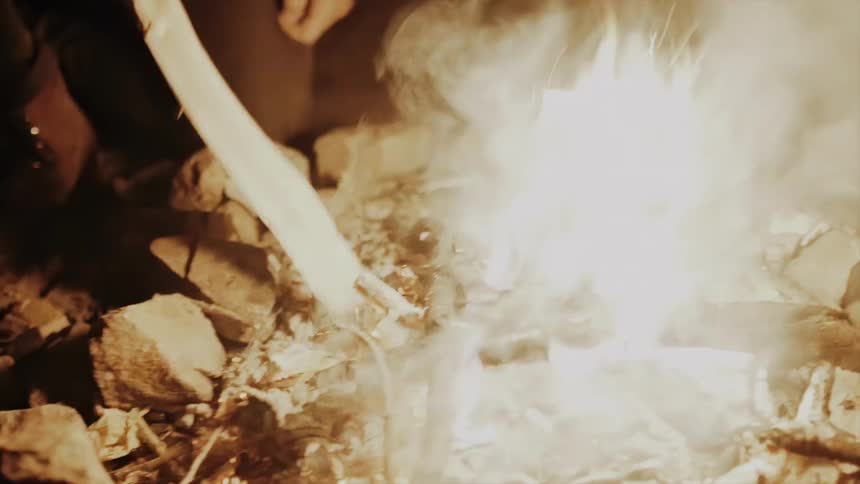Man building a campfire at night
