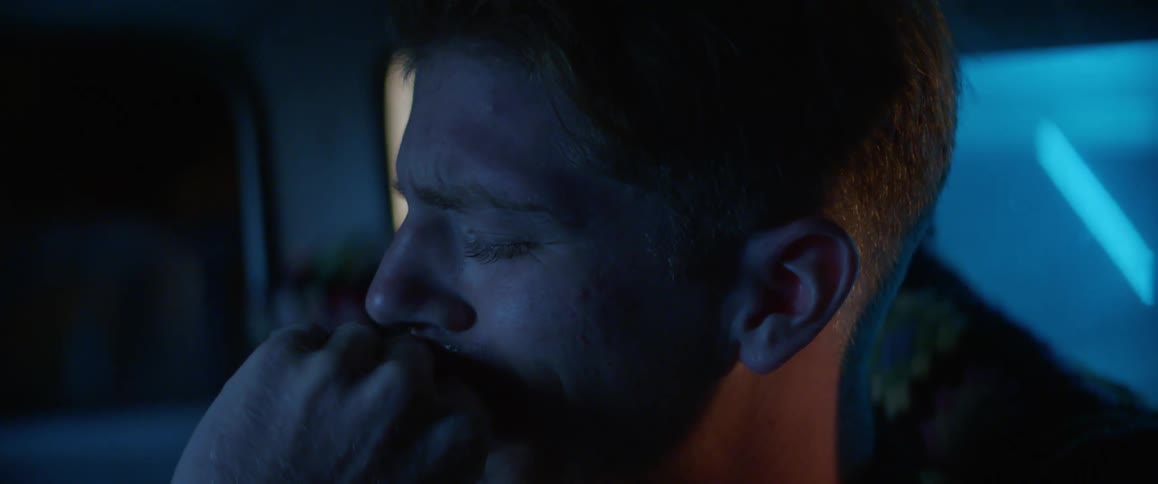 Close up of a sad man crying in his car at night